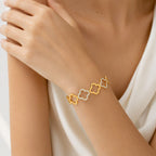 Multi four-leaf clover station and pave cubic zirconia accent stainless steel jewelry bangle in waterproof 18k gold plated finish.