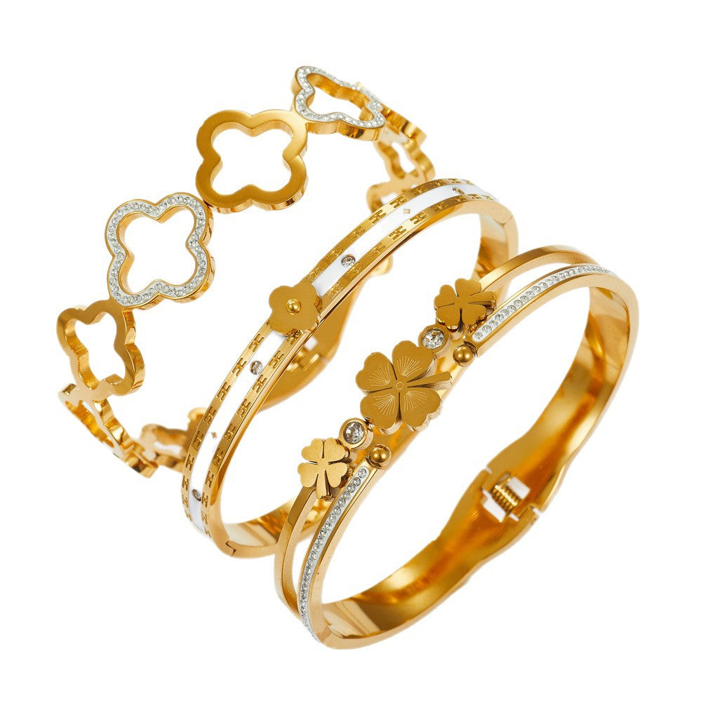 Multi four-leaf clover station and pave cubic zirconia accent stainless steel jewelry bangle in waterproof 18k gold plated finish.