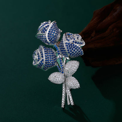 Elegant floral bouquet brooch with purple and blue cubic zirconia petals and a sparkling silver-tone stem
