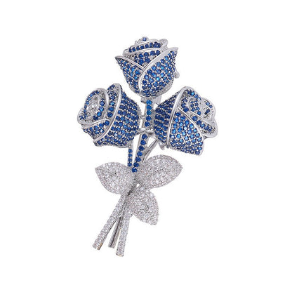 Elegant floral bouquet brooch with purple and blue cubic zirconia petals and a sparkling silver-tone stem