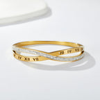 Engraved Roman numeral and pave cubic zirconia crossover stainless steel bangle bracelet jewelry in waterproof 18k gold plated finish.
