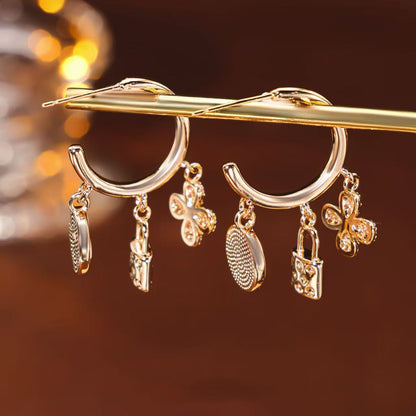 Rose gold huggie hoop earrings featuring a sparkling zirconia pave and a delicate four-leaf clover charm