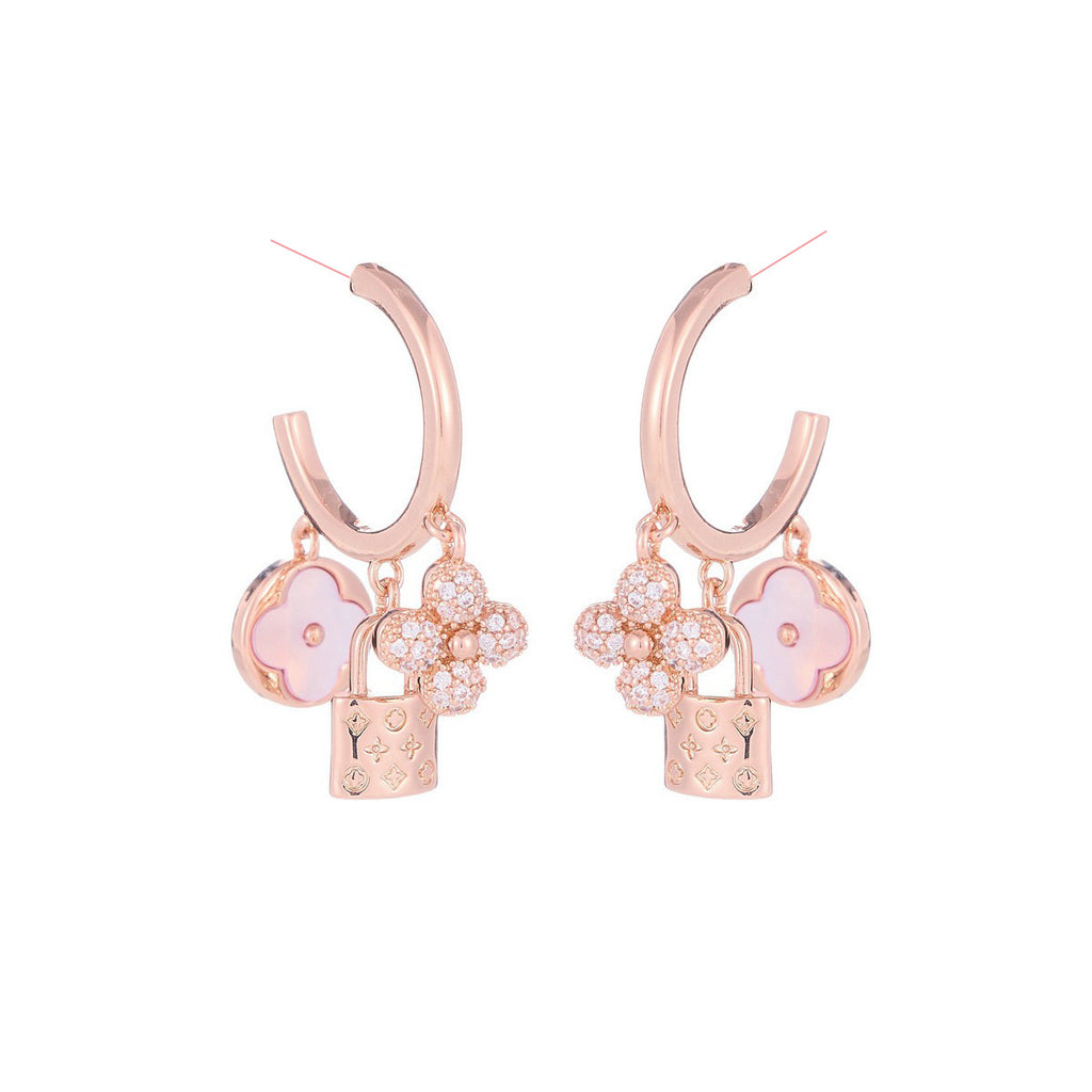 Rose gold huggie hoop earrings featuring a sparkling zirconia pave and a delicate four-leaf clover charm