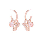 Rose gold huggie hoop earrings featuring a sparkling zirconia pave and a delicate four-leaf clover charm