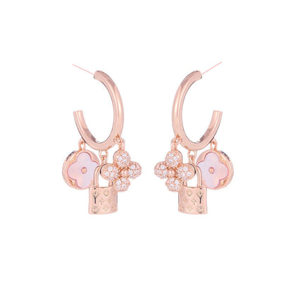 Rose gold huggie hoop earrings featuring a sparkling zirconia pave and a delicate four-leaf clover charm