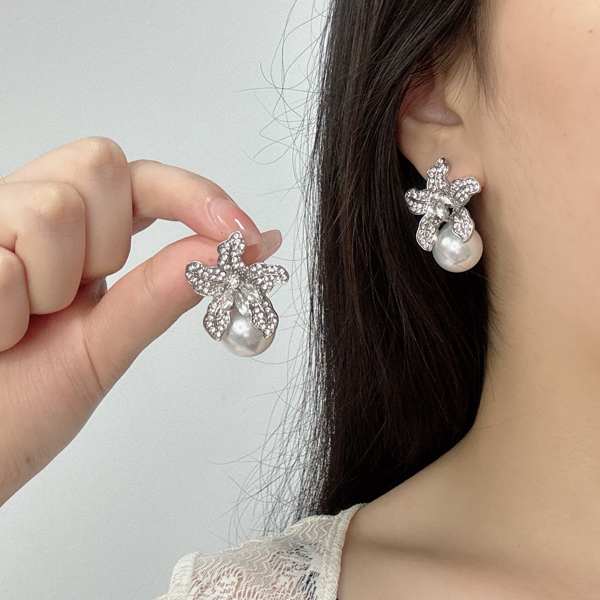 Elegant S925 sterling silver lily flower stud earrings featuring a lustrous white pearl center in a silver tone