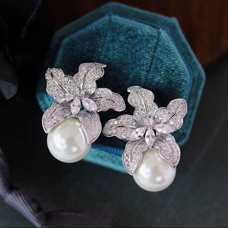 Elegant S925 sterling silver lily flower stud earrings featuring a lustrous white pearl center in a silver tone