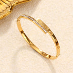 Engraved screw motif and channel-set cubic zirconia T-bar hinged cuff bangle in waterproof 18k gold plated stainless steel jewelry.