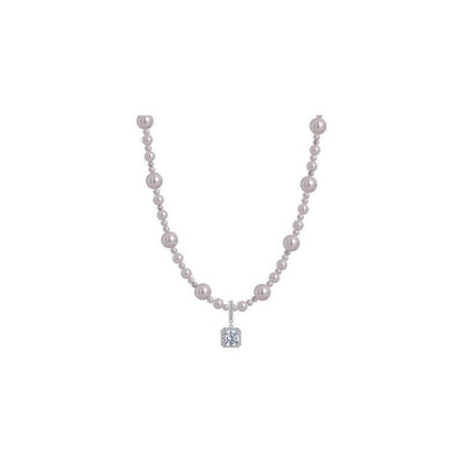 Modern silver-tone necklace featuring a sleek arc pendant with a dangling round pearl and shimmering zircon accents
