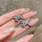 Silver bowknot stud earrings featuring a delicate ribbon design fully set with sparkling clear zirconia stones