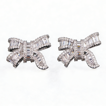 Silver bowknot stud earrings featuring a delicate ribbon design fully set with sparkling clear zirconia stones