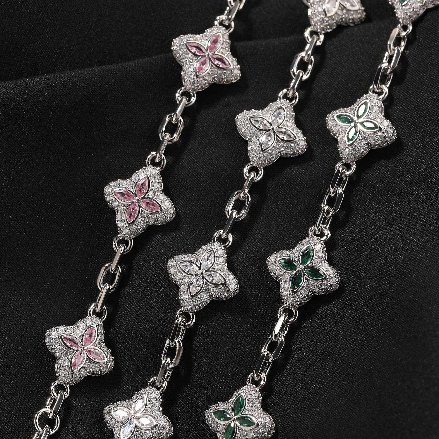 Elegant silver four-leaf clover bangle with pink and green gemstone centers surrounded by a sparkling zirconia halo