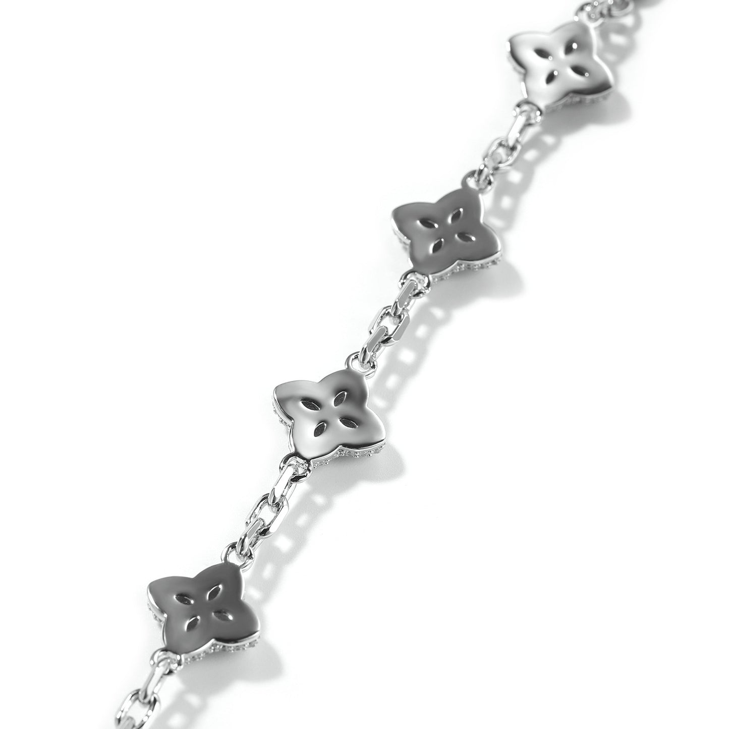 Elegant silver four-leaf clover bangle with pink and green gemstone centers surrounded by a sparkling zirconia halo