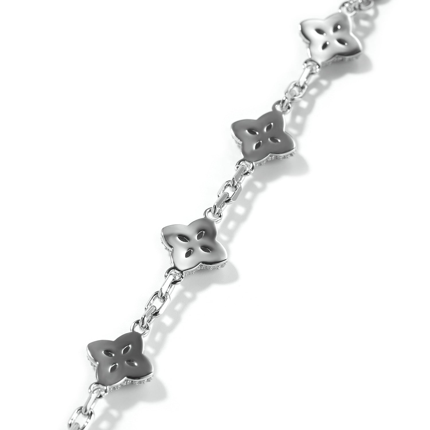 Elegant silver four-leaf clover bangle with pink and green gemstone centers surrounded by a sparkling zirconia halo