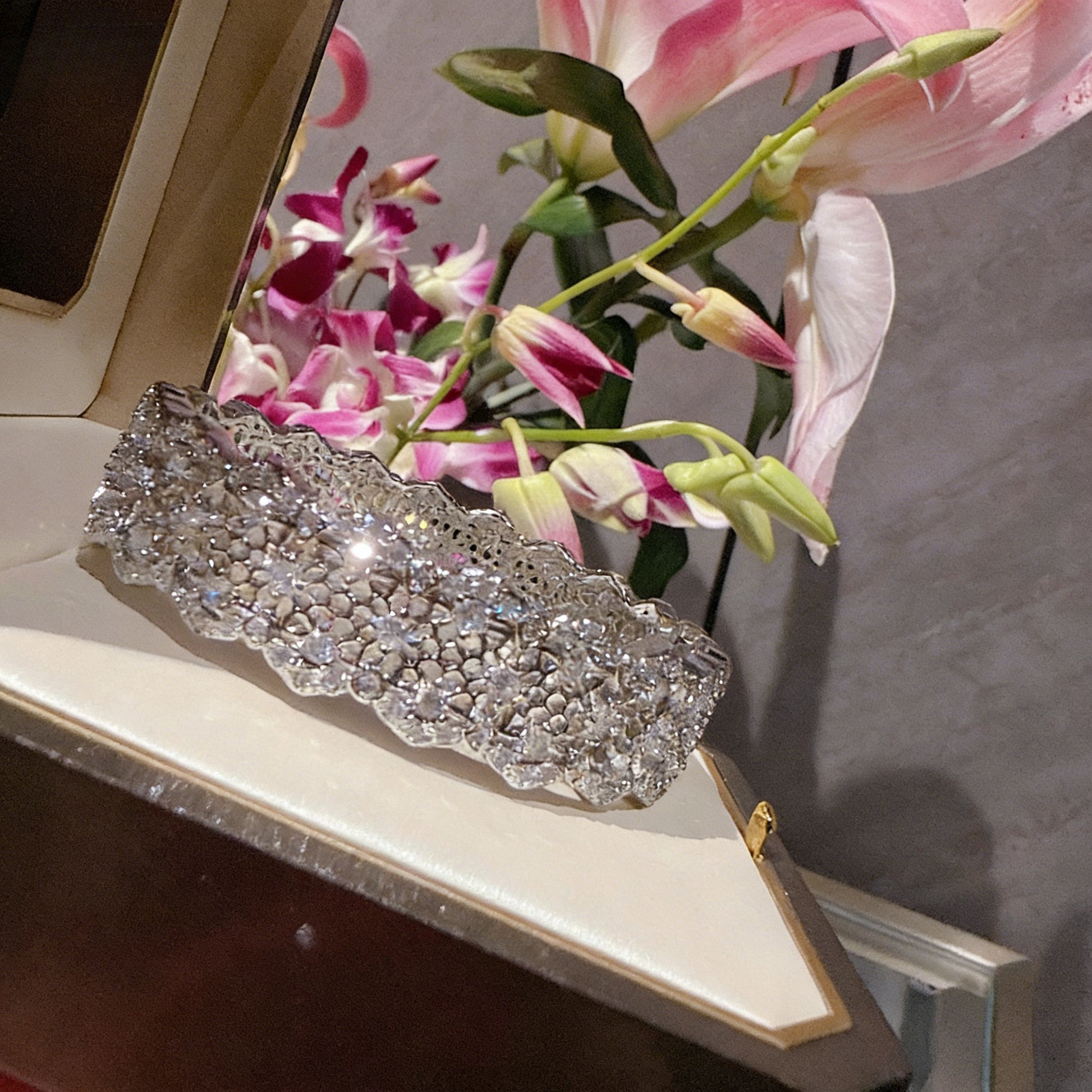 Elegant silver bangle with an intricate lace-inspired cutout pattern and sparkling white cubic zirconia