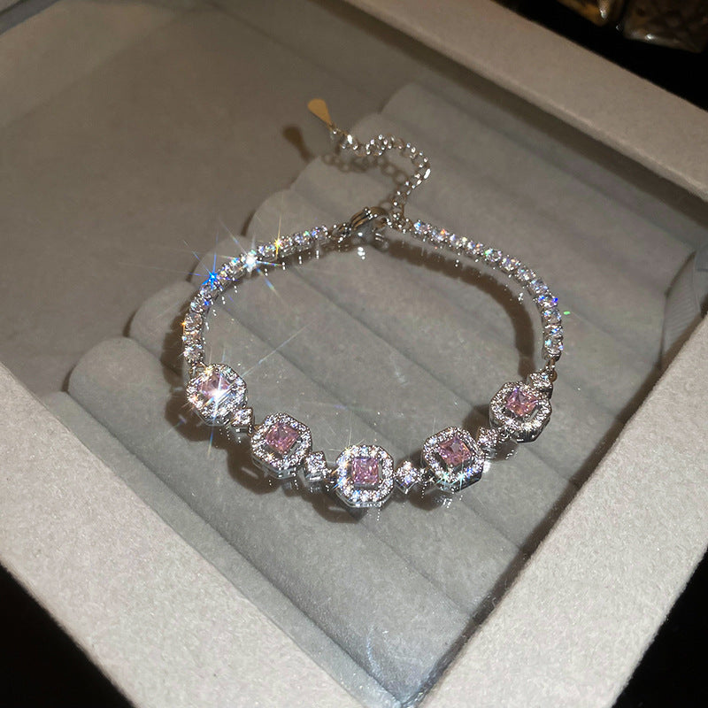 Elegant silver tennis bracelet with a pink round halo center stone and sparkling white cubic zirconia