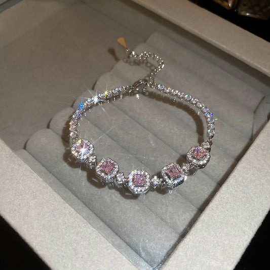 Elegant silver tennis bracelet with a pink round halo center stone and sparkling white cubic zirconia