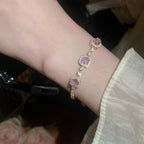 Elegant silver tennis bracelet with a pink round halo center stone and sparkling white cubic zirconia