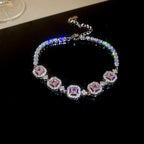 Elegant silver tennis bracelet with a pink round halo center stone and sparkling white cubic zirconia