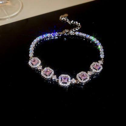Elegant silver tennis bracelet with a pink round halo center stone and sparkling white cubic zirconia