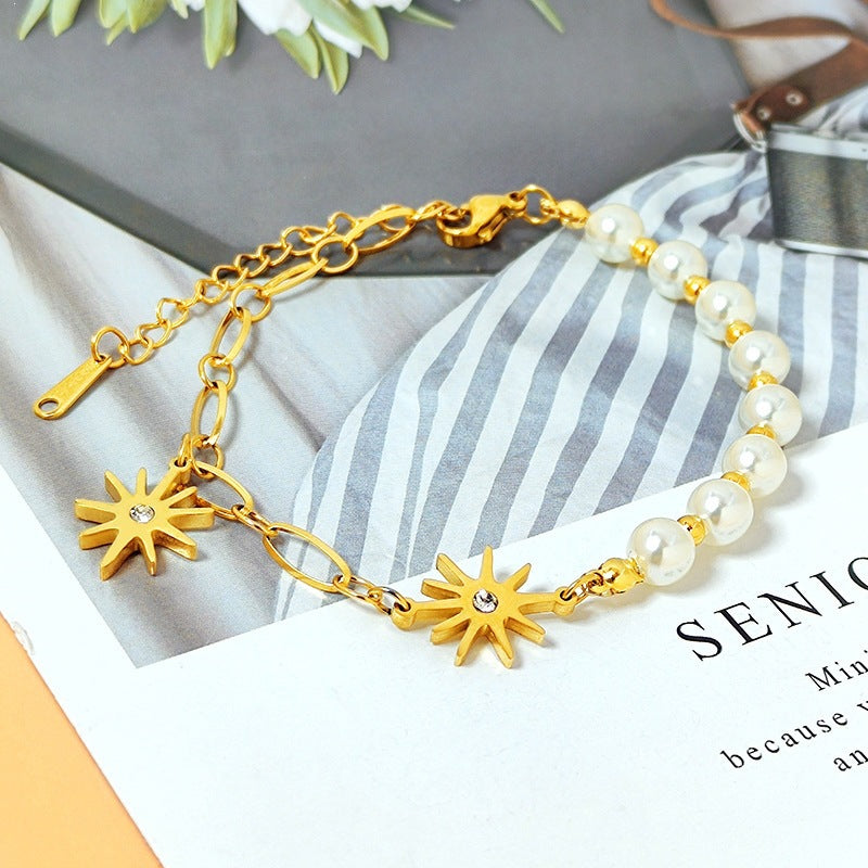 Starburst crystal charms round pearl bead strand paperclip link chain stainless steel jewelry bracelet in waterproof 18k gold plated finish.