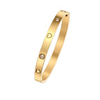 Engraved heart and bezel-set cubic zirconia hinged cuff bangle in waterproof 18k gold plated stainless steel jewelry.