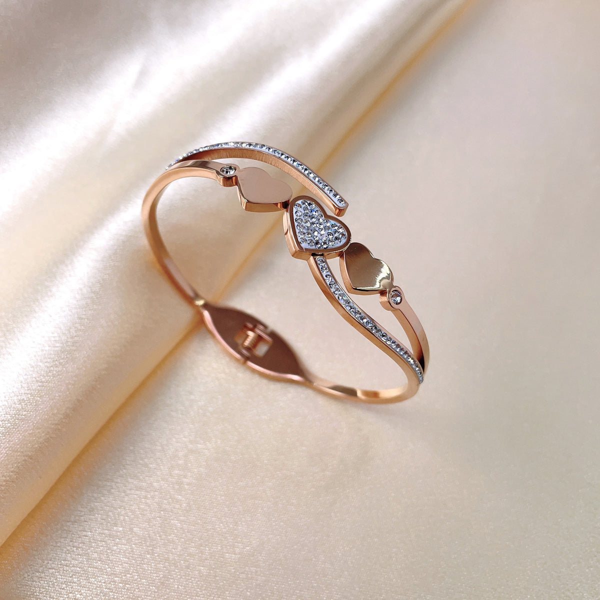 Triple heart station and pave cubic zirconia accent hinged cuff bangle in waterproof 18k gold plated stainless steel jewelry.