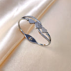 Triple heart station and pave cubic zirconia accent hinged cuff bangle in waterproof 18k gold plated stainless steel jewelry.