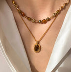 Waterproof stainless steel jewelry collection featuring hypoallergenic gold plated natural tiger eye pendant necklace and baroque pearl beaded necklace options