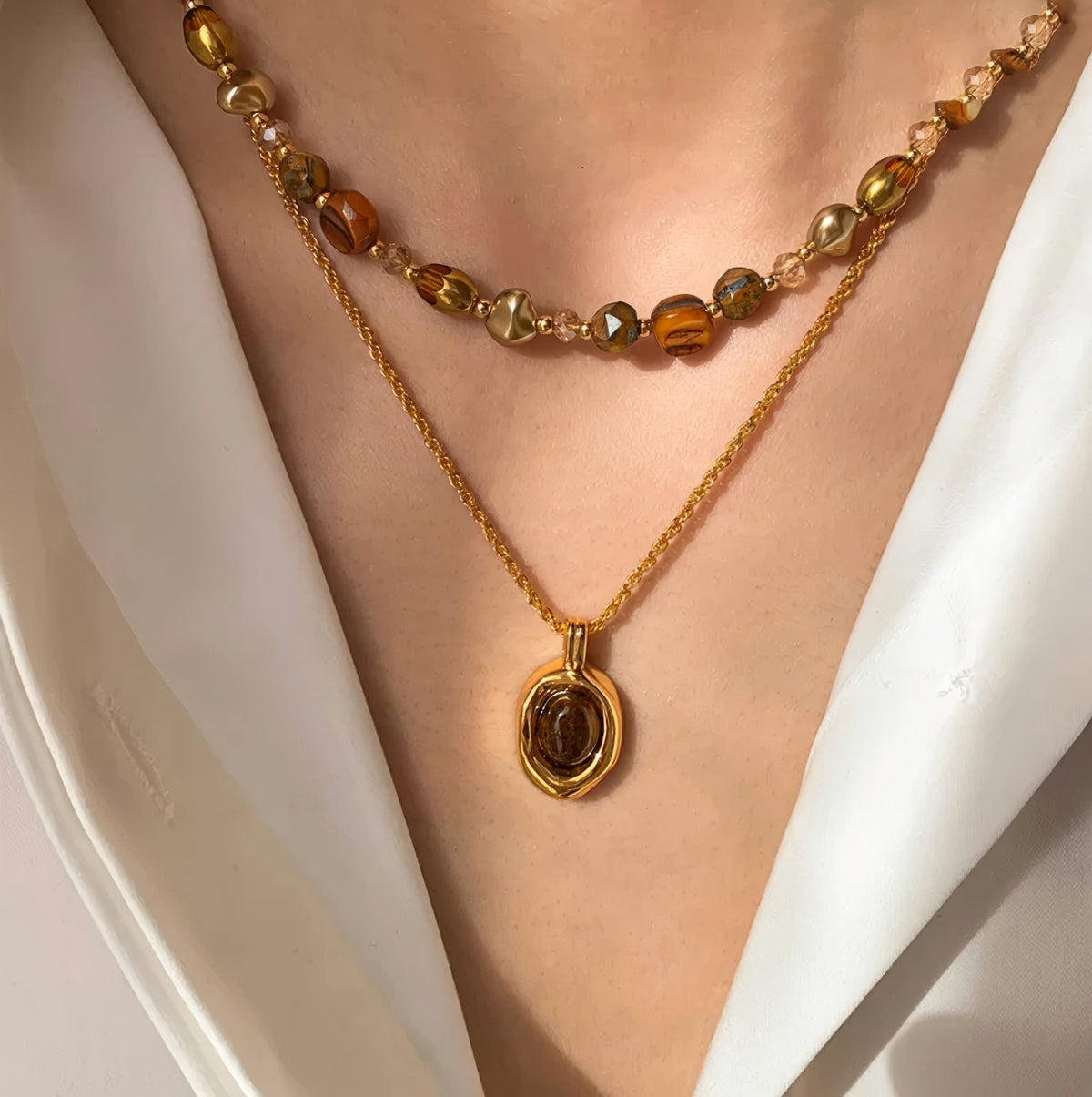 Waterproof stainless steel jewelry collection featuring hypoallergenic gold plated natural tiger eye pendant necklace and baroque pearl beaded necklace options