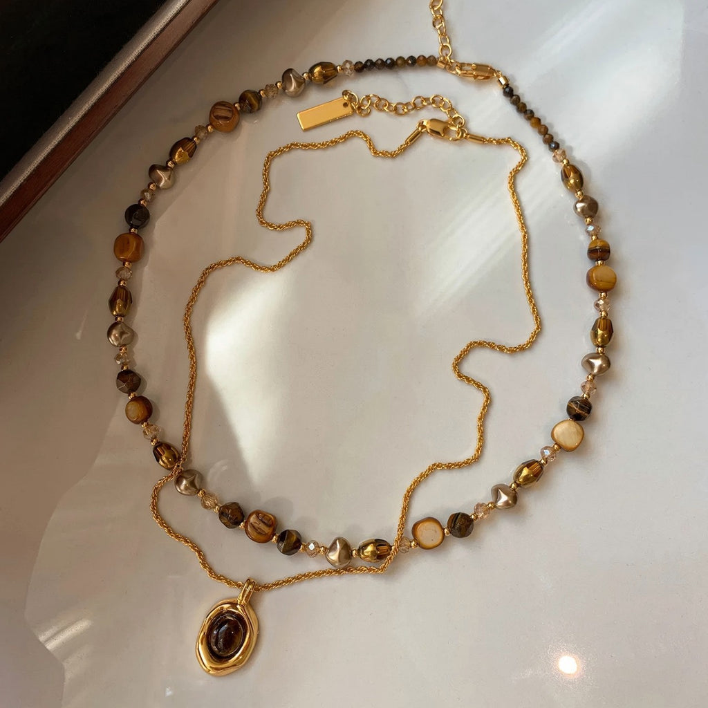 Waterproof stainless steel jewelry collection featuring hypoallergenic gold plated natural tiger eye pendant necklace and baroque pearl beaded necklace options