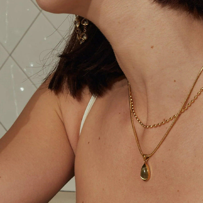 Waterproof stainless steel jewelry collection featuring hypoallergenic gold plated olive green glass teardrop pendant snake chain necklace.