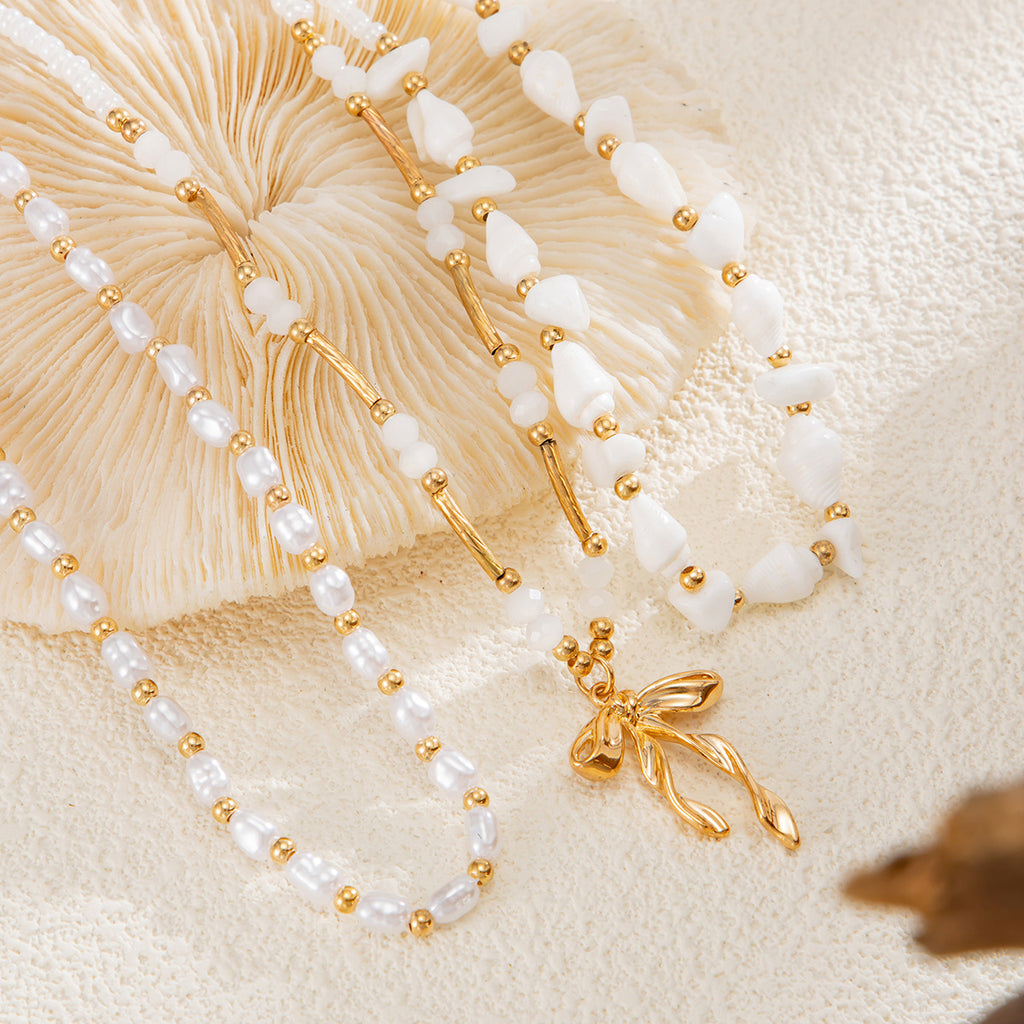 Waterproof stainless steel jewelry collection featuring hypoallergenic gold plated ribbon bow pendant pearl beaded 3-piece layered necklace set.