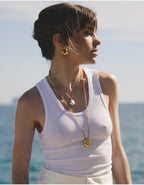Waterproof stainless steel jewelry collection featuring hypoallergenic gold plated titanium steel smooth pebble pendant long necklace.