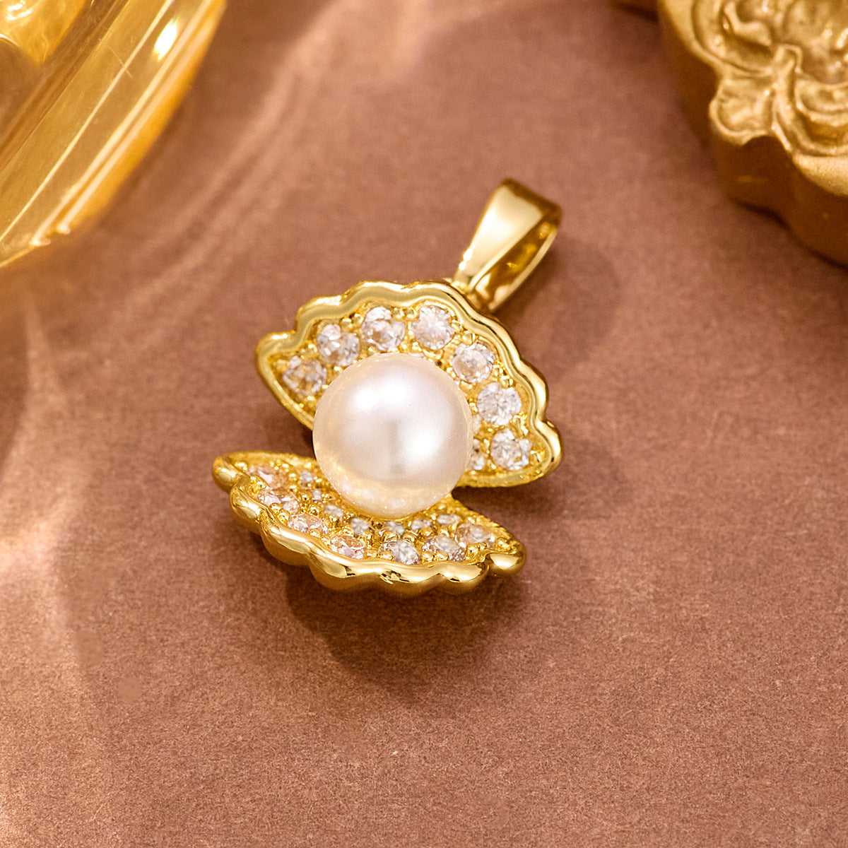 Wholesale stainless steel jewelry collection of gold cz cubic zirconia and pearl pendant charms featuring butterfly, heart, and shell designs.