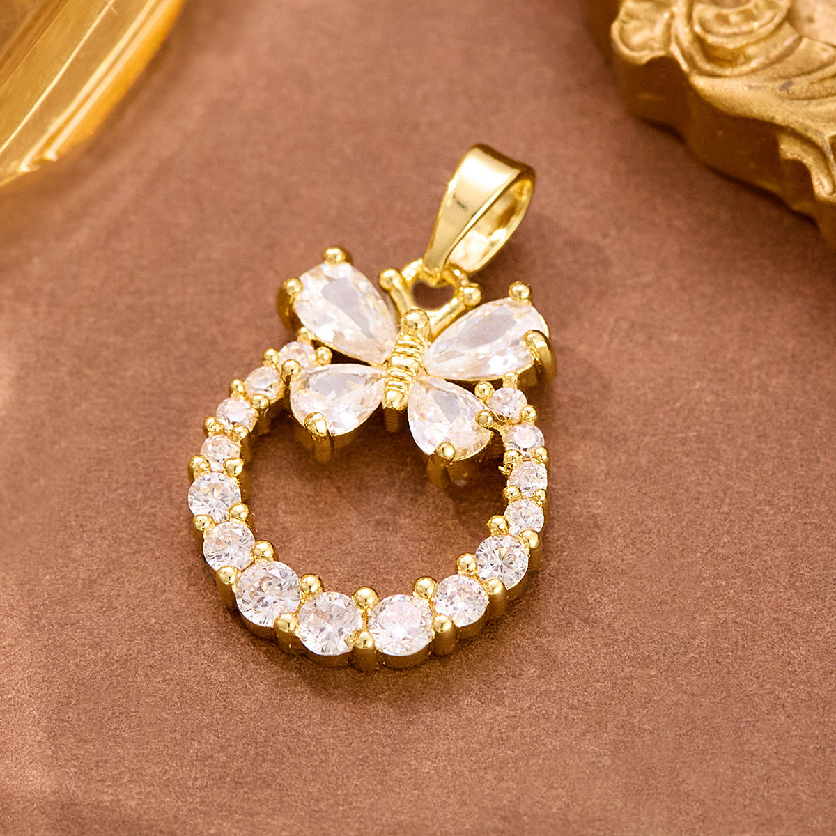 Wholesale stainless steel jewelry collection of gold cz cubic zirconia and pearl pendant charms featuring butterfly, heart, and shell designs.
