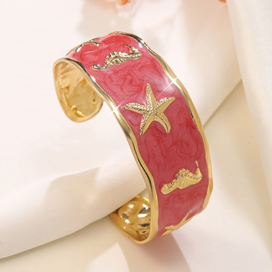Wholesale stainless steel jewelry low MOQ 304 stainless steel gold enamel cuff bangle bracelet with starfish and seahorse motifs.